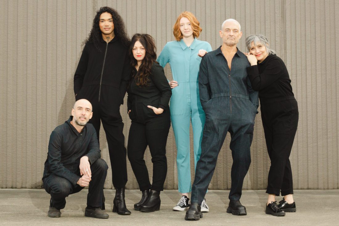 six people wearing coveralls